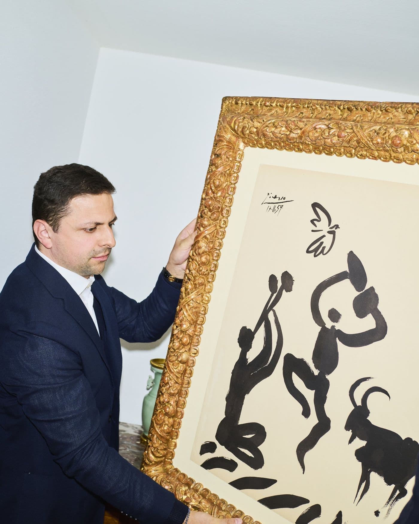 Elia Himmelreich trägt eine gerahmte Picasso-Lithografie durch das Auktionshaus